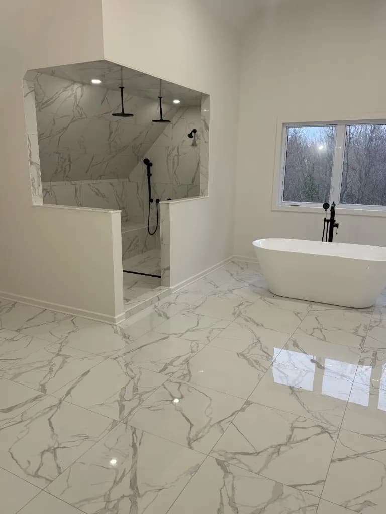 Luxury marble-look bathroom with freestanding tub and curbless walk-in shower