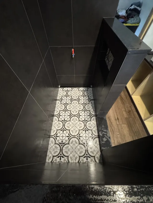 Surface Renaud – dark tile shower with patterned floor overhead view