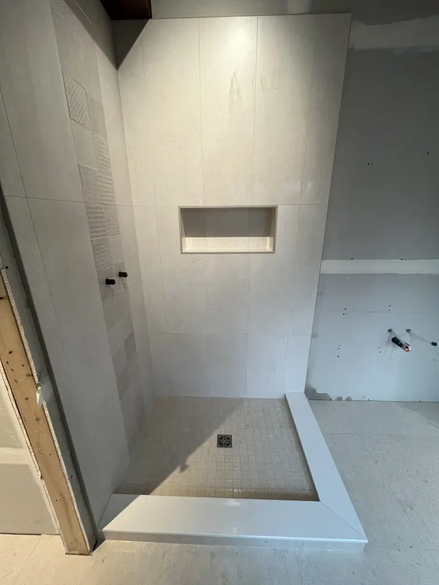 Surface Renaud – light grey shower with textured accent tile strip