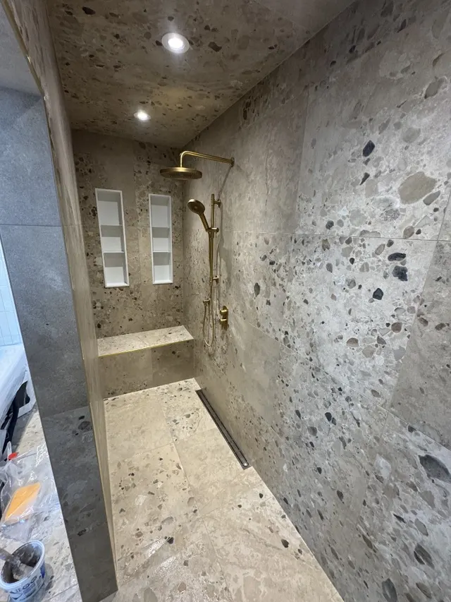 Surface Renaud – terrazzo shower with built-in niches and bench seating