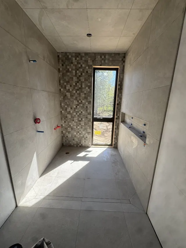 Surface Renaud – walk-in shower with mosaic accent wall and natural light