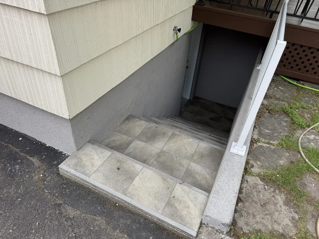 Surface Renaud – exterior stairwell with grey architectural coating and tiled steps