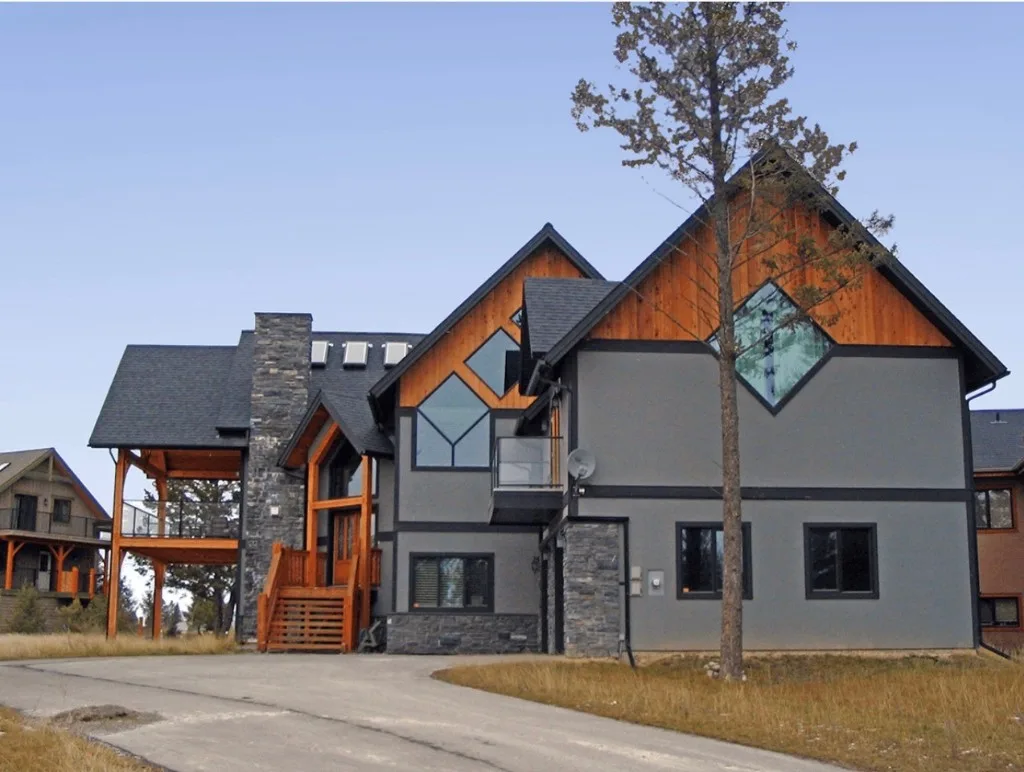 Surface Renaud – modern home with grey coating, wood accents, and stone masonry