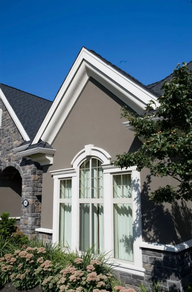 Surface Renaud – taupe architectural coating with stone and white trim detailing