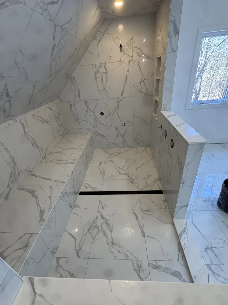 Surface Renaud – marble-look walk-in shower with built-in bench and recessed niche
